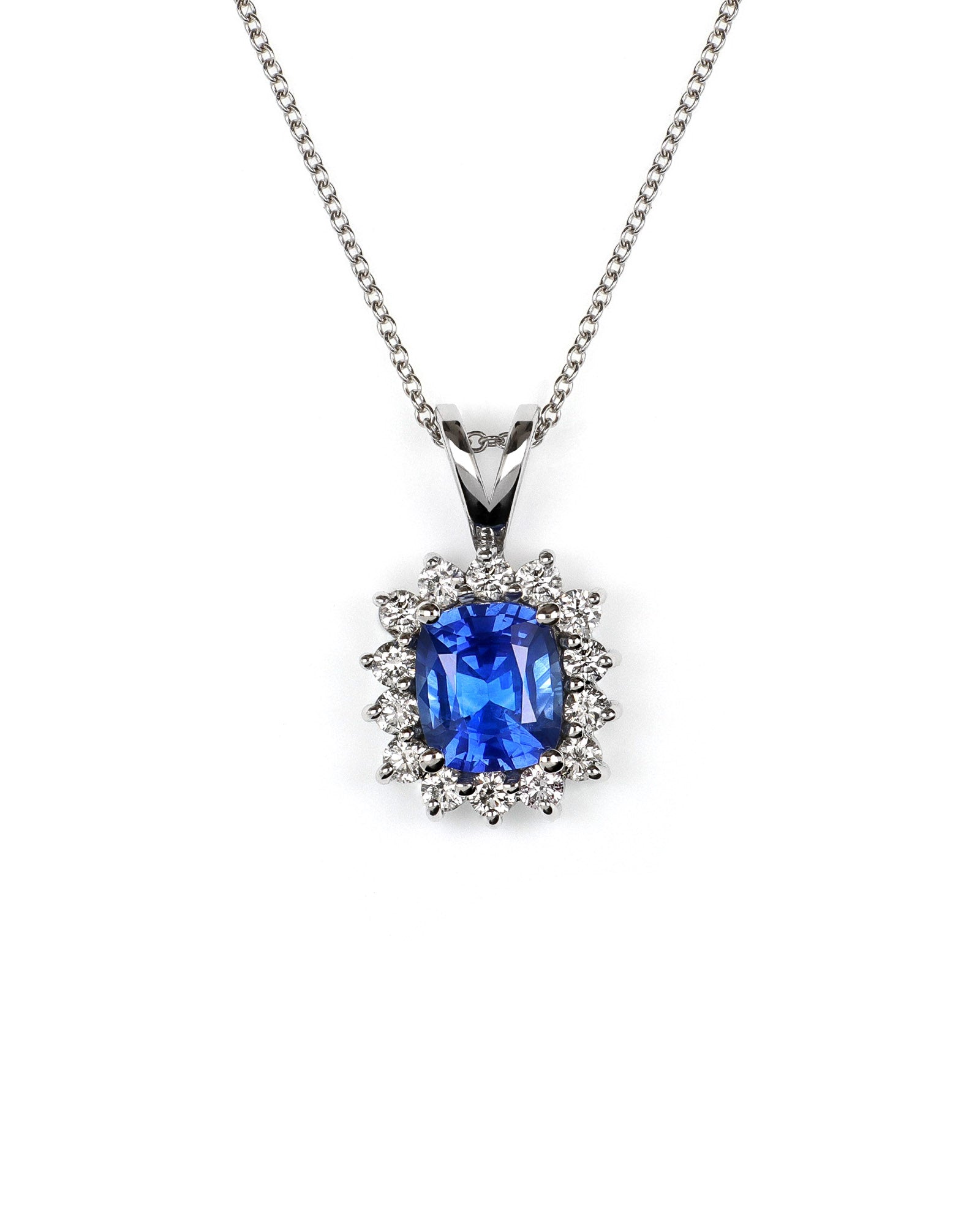 vivid blue sapphire surrounded by diamonds in this classic halo pendant with split bail on a white gold chain. The pendant is on a white background