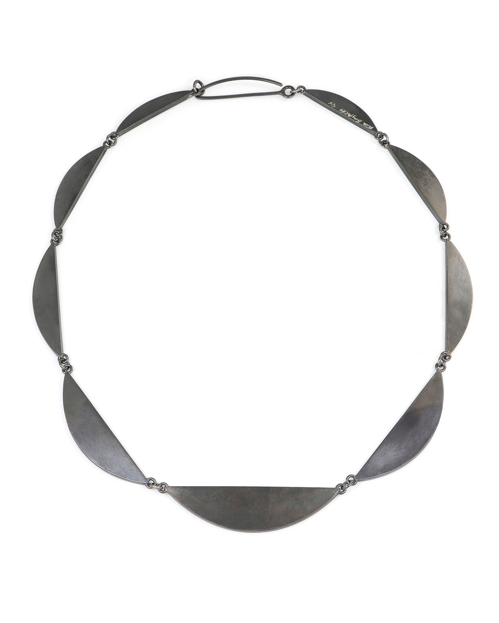 Silver necklace with leaf-like pendants on a white background