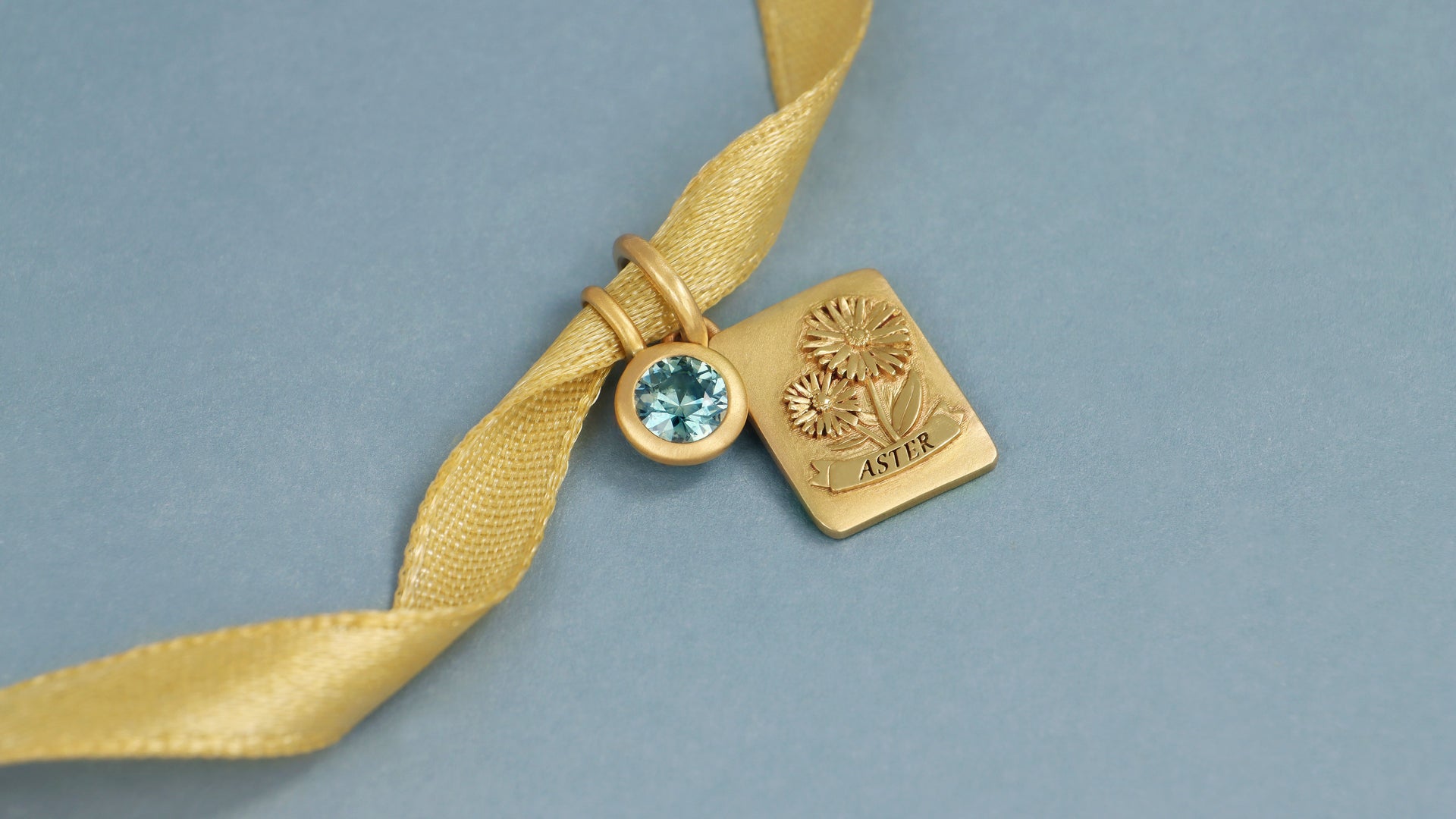 Gold ribbon with September birthstone and birth month flower pendant in yellow gold